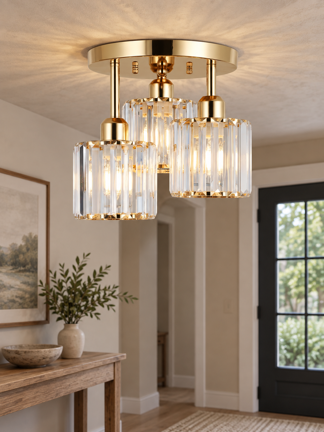 Gold three-shade crystal ceiling light in a warm entry hall.